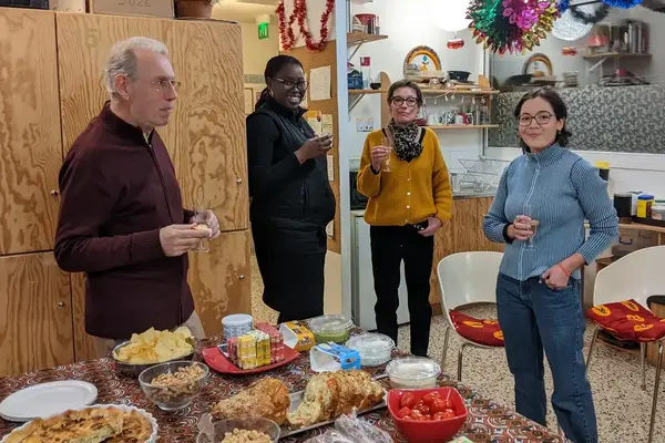 Fête de Noël à la Bagagerie le 24 décembre 2025, bénévoles et accueillis autour d'un buffet.