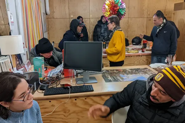 Fête de Noël à la Bagagerie le 24 décembre 2025, bénévoles et accueillis autour d'un buffet.