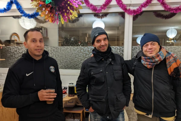 Fête de Noël à la Bagagerie le 24 décembre 2025, bénévoles et accueillis autour d'un buffet.