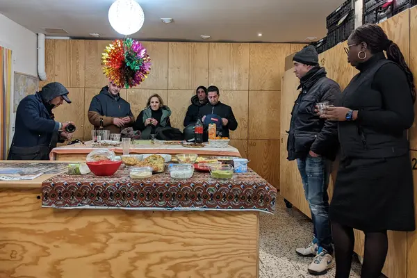 Fête de Noël à la Bagagerie le 24 décembre 2025, bénévoles et accueillis autour d'un buffet.