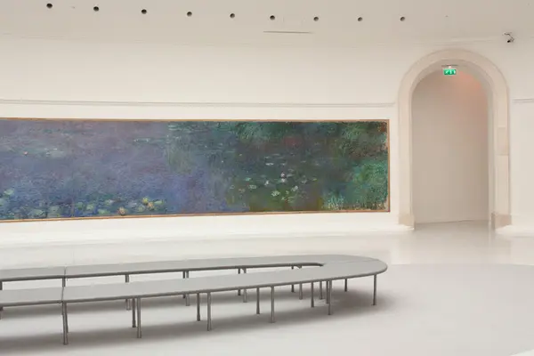 Photo d'une partie des Nymphéas, au musée de l'orangerie, avec au premier blanc, le banc qui fait le tour de la pièce.